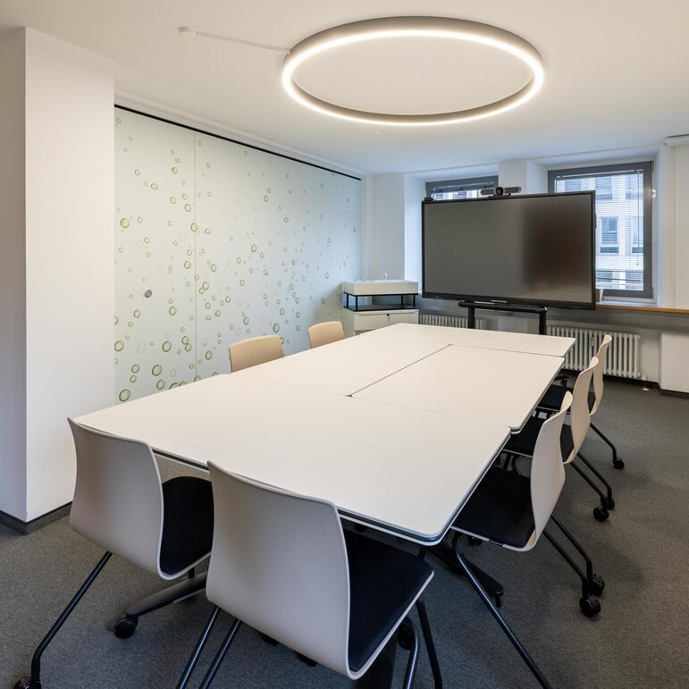 Table at seat height with chairs and WINEA STARTUP 2.0 TV mobile unit