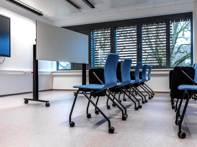 WINEA FLOW MEET elektromotorisch höhenverstellbarer Klapptisch mit Whiteboardoberfläche in Schulungssituation