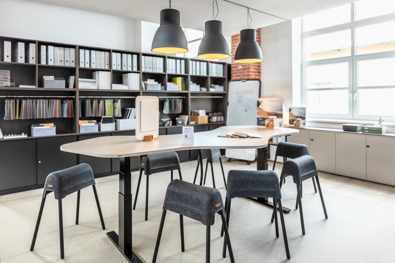 Höhenverstellbarer WINEA PRO Freiformtisch vor WINEA MAXX Schrank- und Regalkombination. WINI Forum Sandsteinhalle, Ausstellung zur Hausmesse 2025