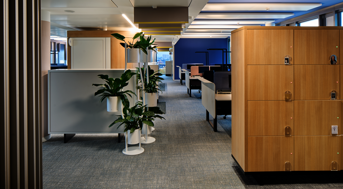 WINEA MAXX Locker, im Hintergrund WINEA FLOW Steh-Sitz-Tische mit Akustikpaneele und Sichtschutz